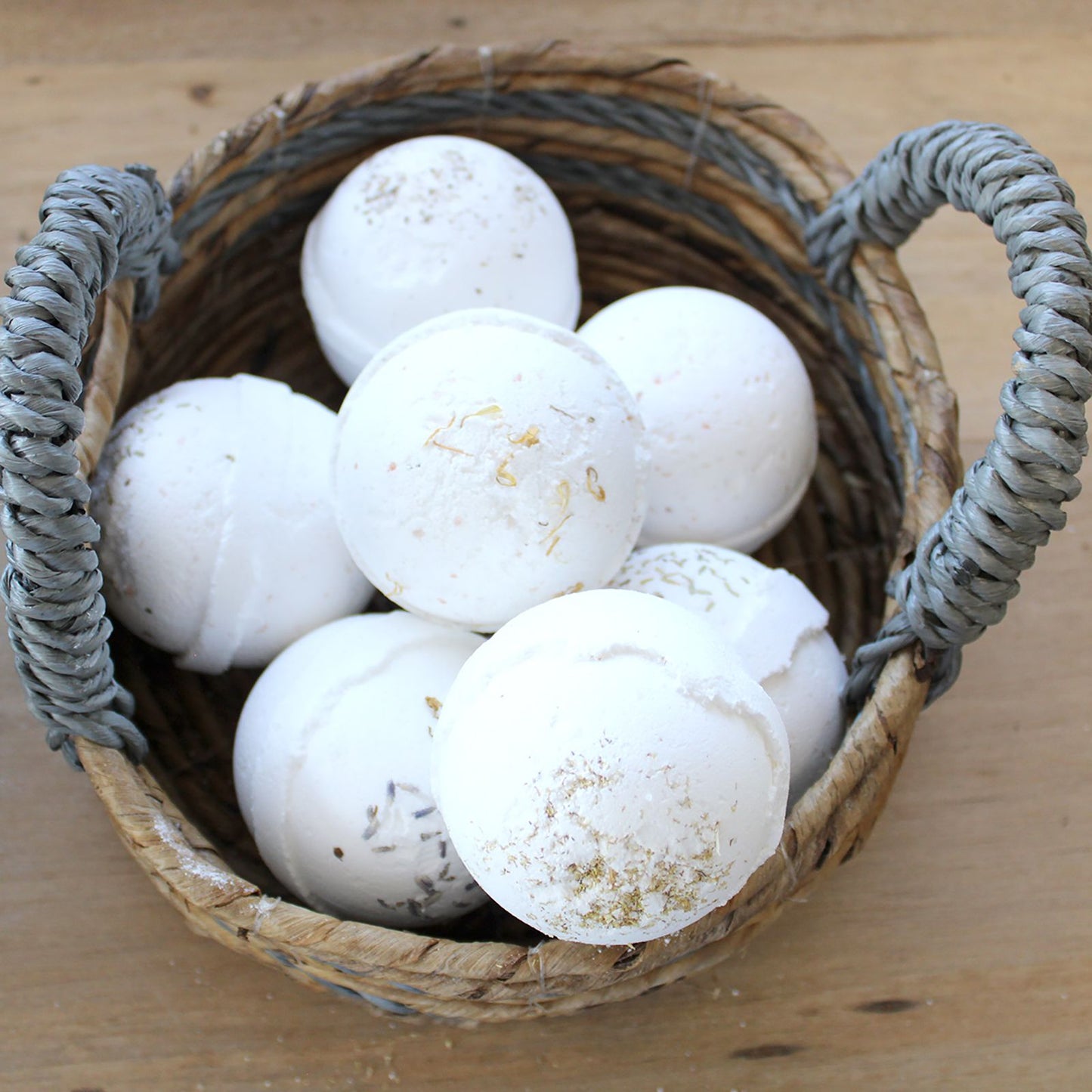 Natural Seagrass Square Baskets – Set of 2 woven seagrass basket with handles holding white bath bombs on wooden surface