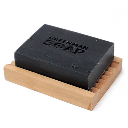 Alt Tag: Natural Spicy Scent Greenman Soap – 100G barra de jabón negro artesanal con carbón activado sobre jabonera de madera