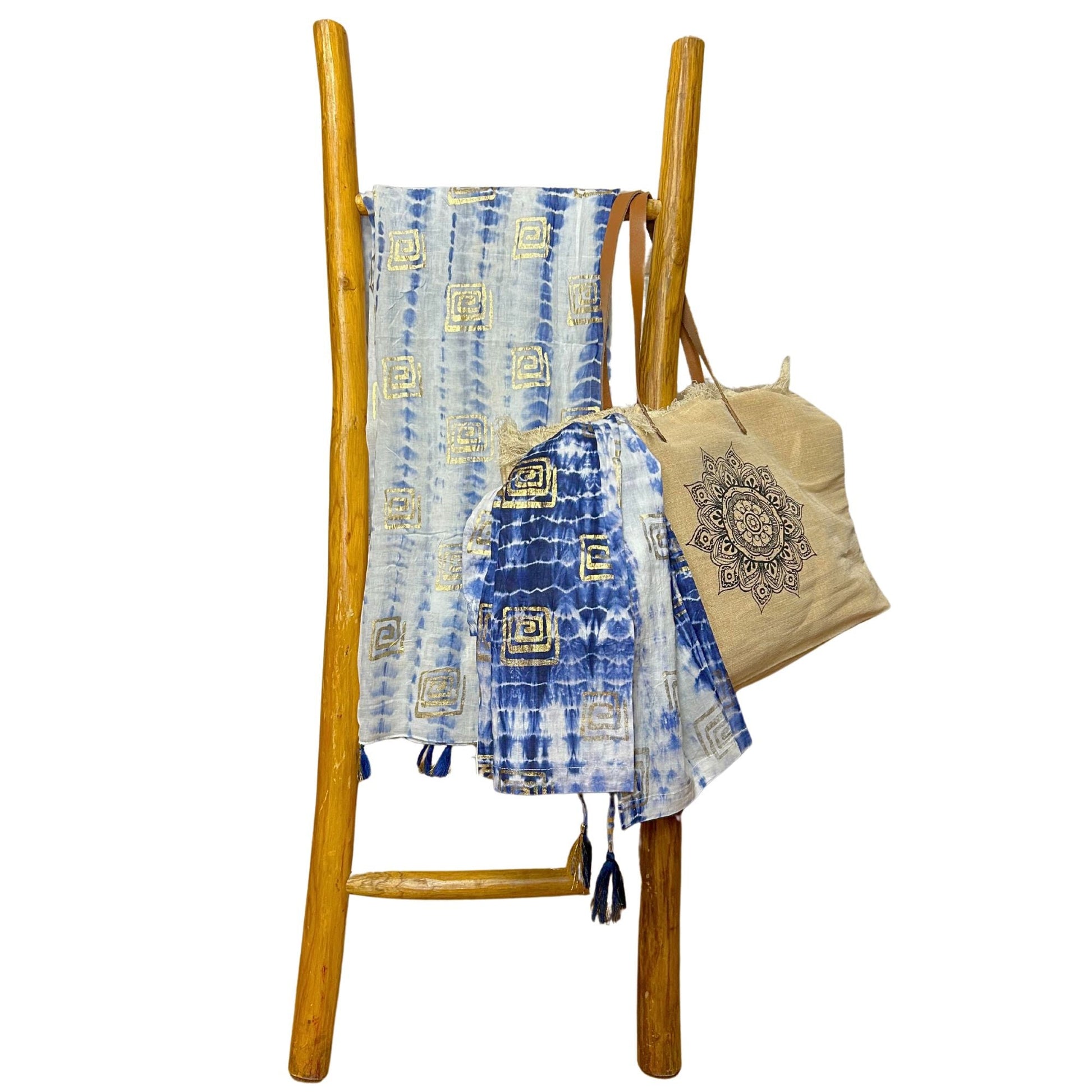 Nomad Sari Pario – blå tie-dye & blockprint hängd på en trästege med beige väska; blå pario i tie-dye med blockprint-detaljer