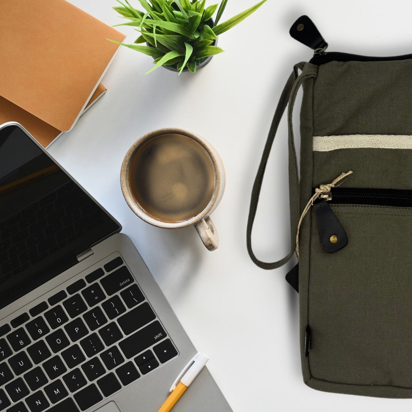 Olivfärgat laptopfodral i canvas – 30x40 CM på skrivbord bredvid laptop, kaffemugg, anteckningsbok och växt, olivfärgat fodral i jute-bomull med rem