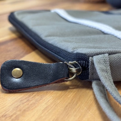 Olive surfplattfodral i jute & bomull – 21x29 CM närbild på dragkedja och läderflärp på olivfärgat tygfodral