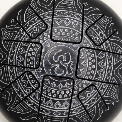 Close view of the silver-grey Om symbol and surrounding geometric engraving on the black drum surface.