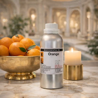Ätherisches Orangenöl – 500G Großflasche auf einem Marmortisch neben einer Schale mit frischen Orangen und einer brennenden Kerze