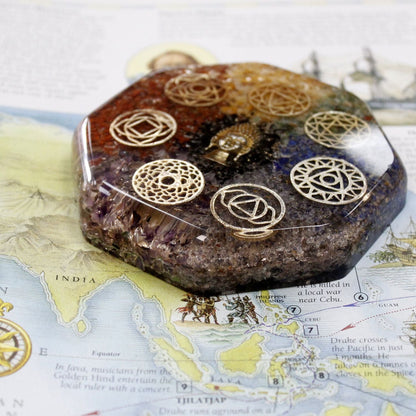Alt Tag: Orgonite Desk Power Pack – Buddha Chakra – Large orgonite paperweight with chakra symbols, resin, metal and crystals on a desk map