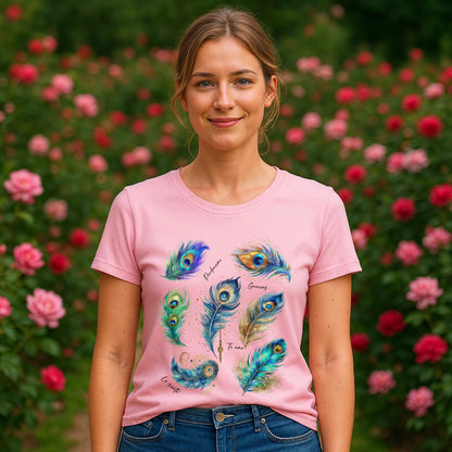 Pavo Real Hooponopono Premium Unisex T-Shirt en color rosa con diseño de plumas de pavo real, modelo de frente en jardín con flores