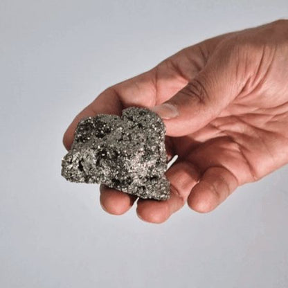 Alt Tag: Gemstone Rare Mineral Specimens – 100-135G 55-65MM Peruvian pyrite mineral specimen held in hand, metallic crystal texture close-up