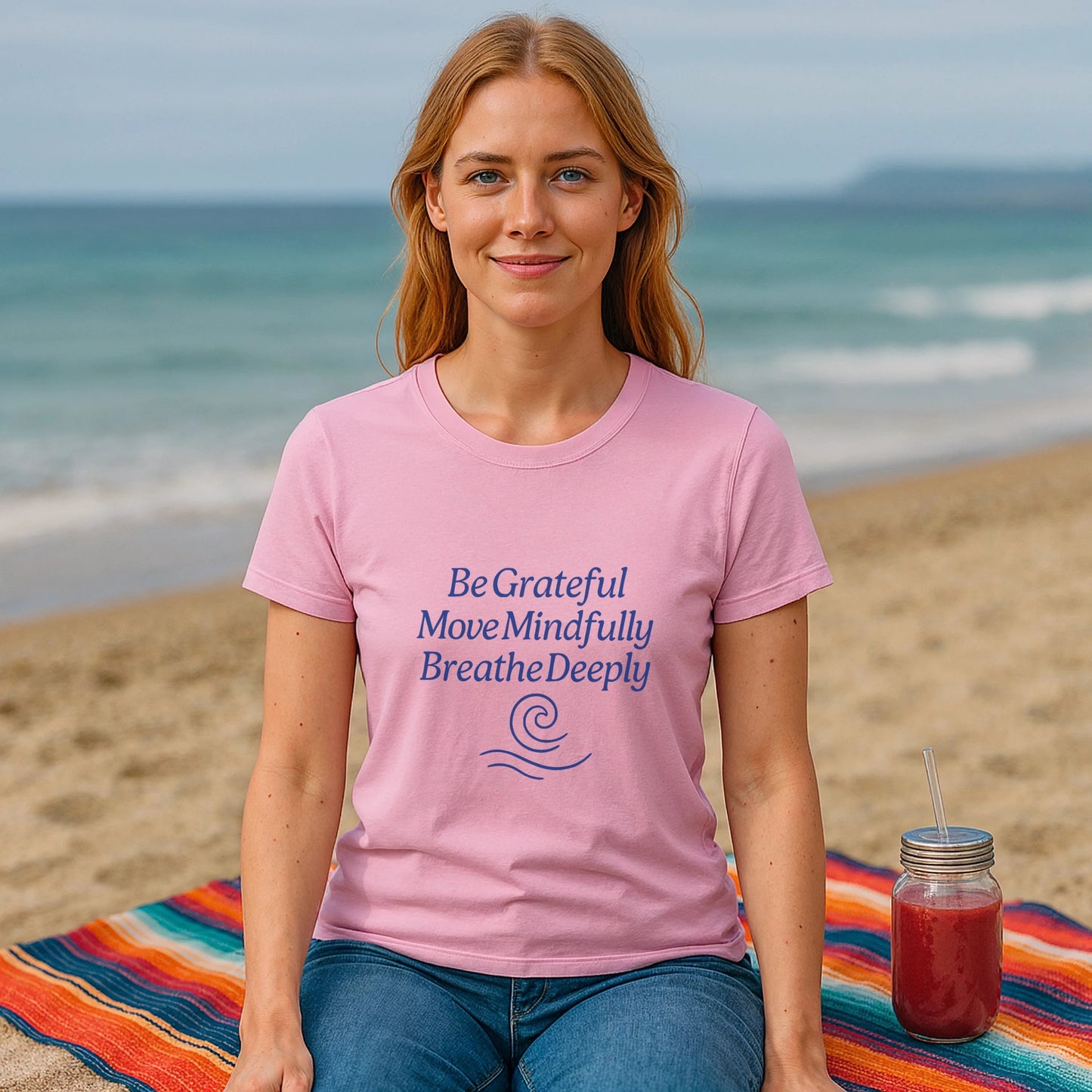Yoga 100% Organic Cotton T-Shirt pink tee with mindful quote, worn by woman sitting on beach blanket