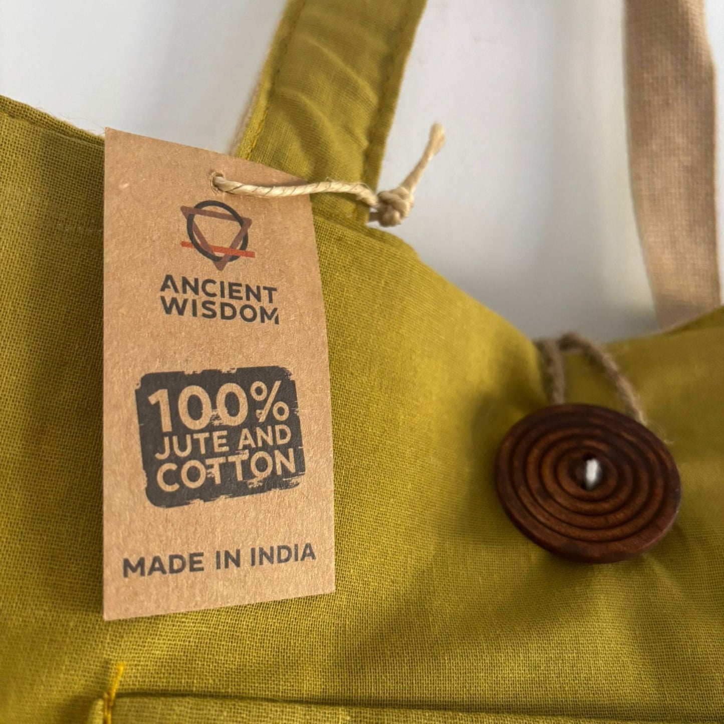 Alt Tag: Pistachio Reversible Jute & Cotton Bag – 49x40 CM close-up pistachio fabric with 100% jute and cotton tag and wooden button