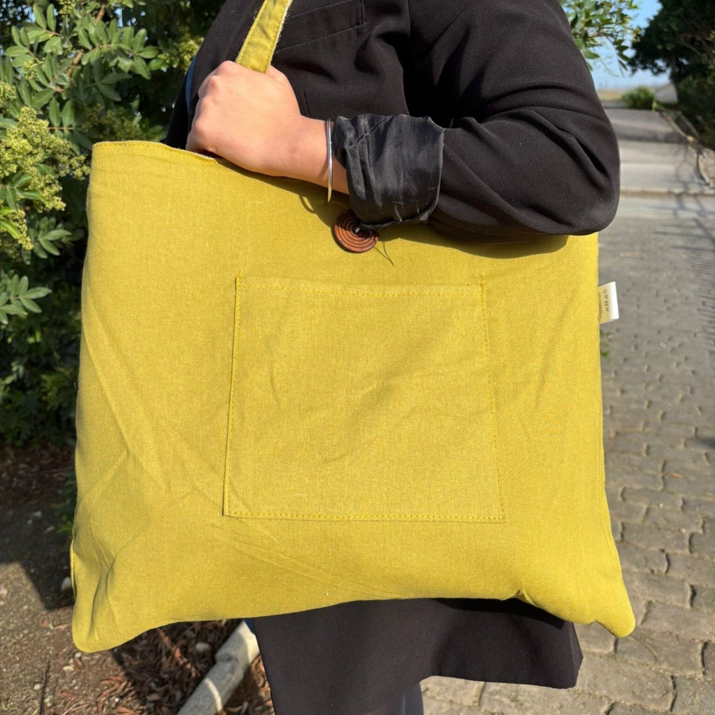Pistachio Reversible Jute & Cotton Bag – 49x40 CM pistachio-green tote bag with front pocket, carried on shoulder outdoors