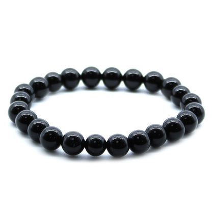 Alt Tag: Power Bracelet – Black Agate pulsera elástica artesanal de cuentas redondas de ágata negra pulida, vista frontal sobre fondo blanco