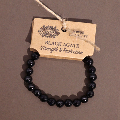 Power Bracelet – Black Agate black agate bead bracelet, polished round gemstone beads, product tag on gray background