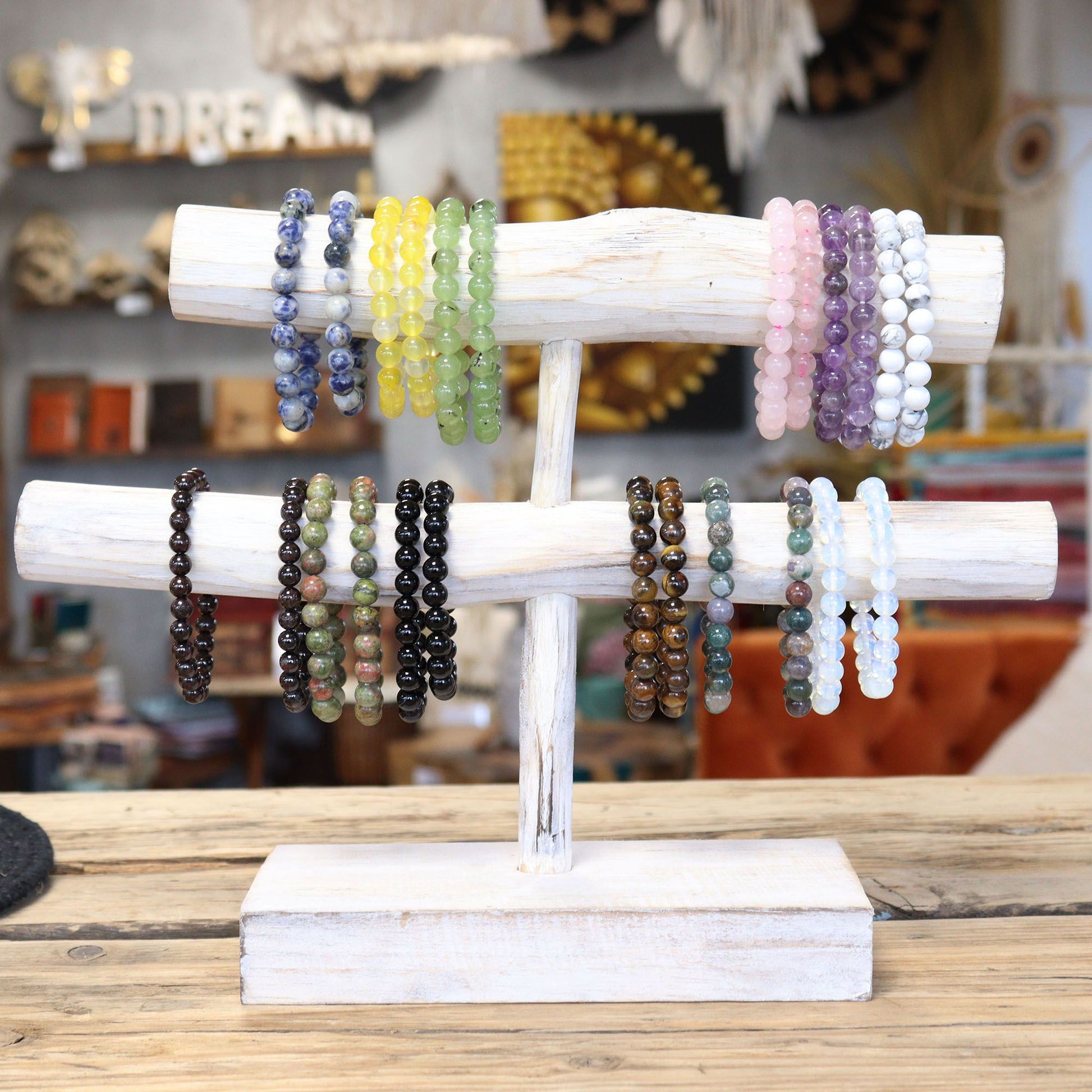 Alt Tag: Power Bracelet – Honey Crystal pulsera de cuentas de cristal color miel en exhibidor de madera con otras pulseras de gemas naturales