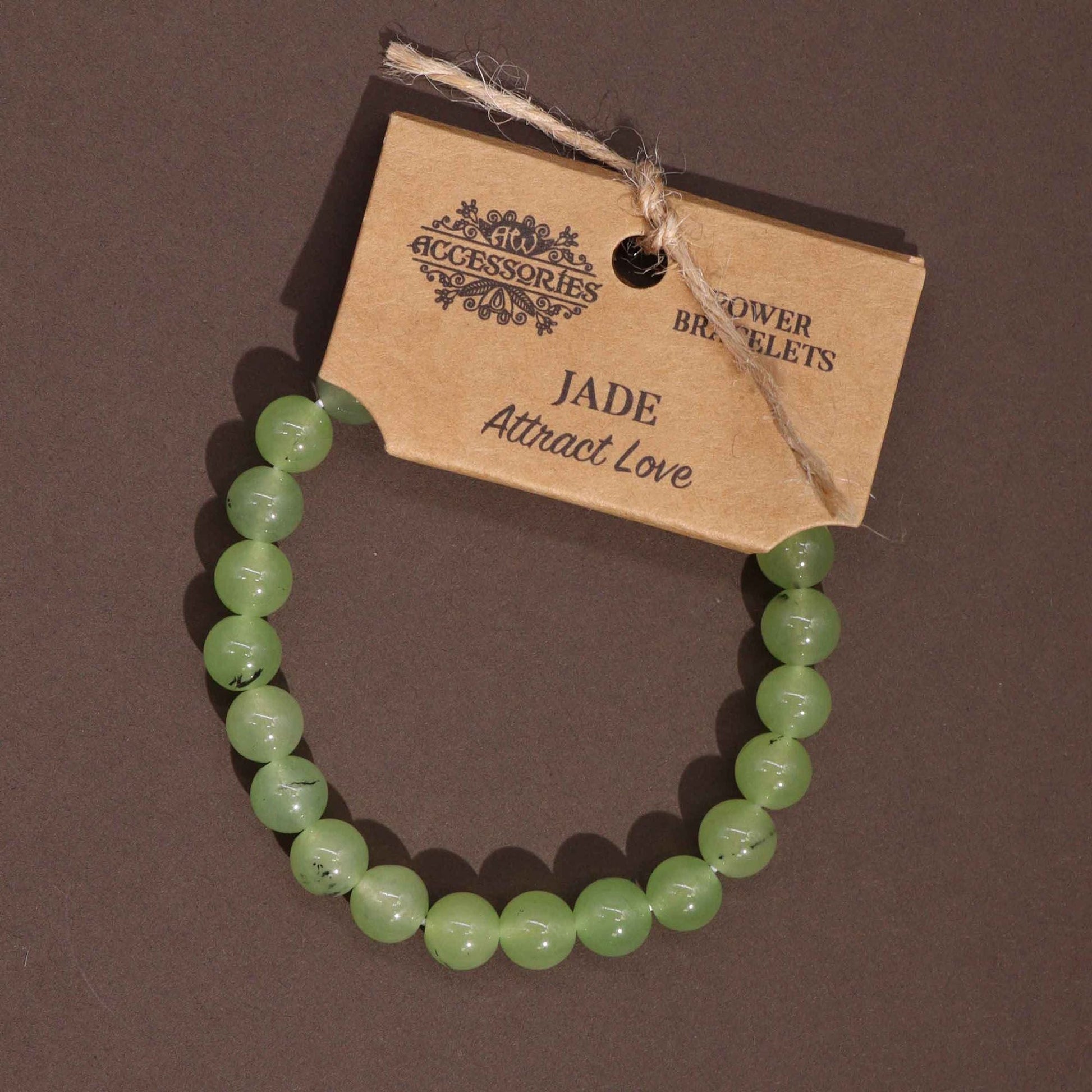 Alt Tag: Power Bracelet - Jade pulsera de cuentas de jade verde con etiqueta Kraft, vista superior sobre fondo oscuro