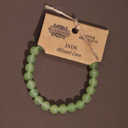 Alt Tag: Power Bracelet - Jade pulsera de cuentas de jade verde con etiqueta Kraft, vista superior sobre fondo oscuro