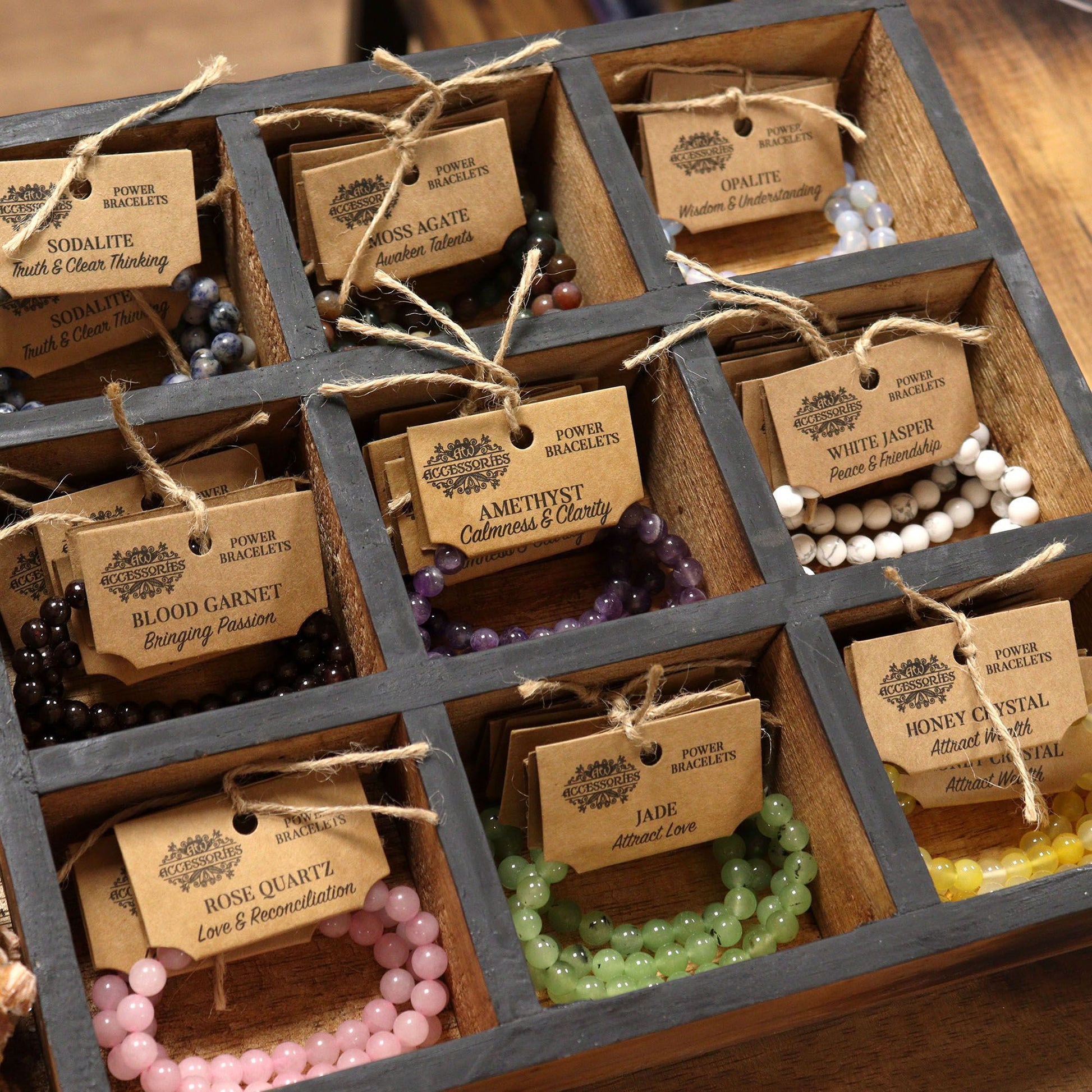 Power Bracelet – Black Agate display of gemstone bead bracelets in wooden grid box with labeled kraft tags