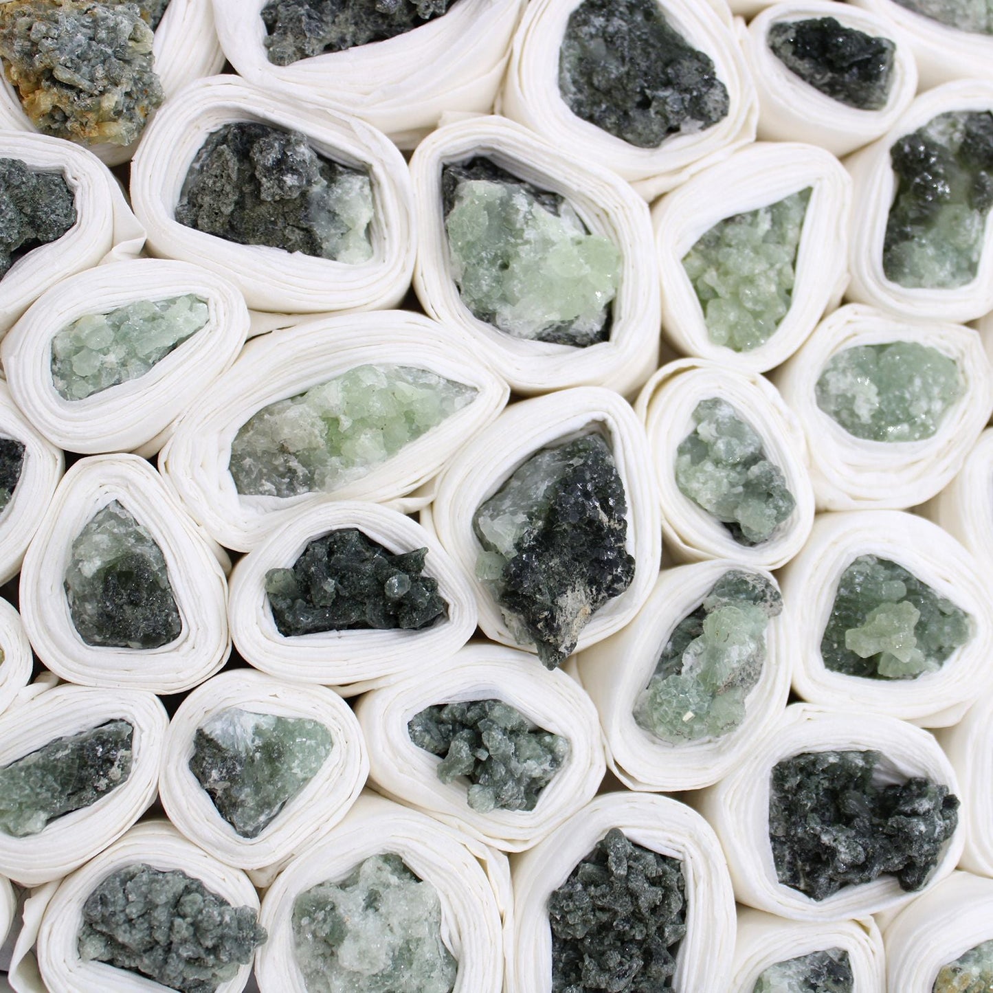Alt-Tag: Prehnit-Mineralstücke – ca. 100 Stück, grüne druzy Prehnit-Kristalle in weißer Verpackung, Mineralienposten aus Marokko