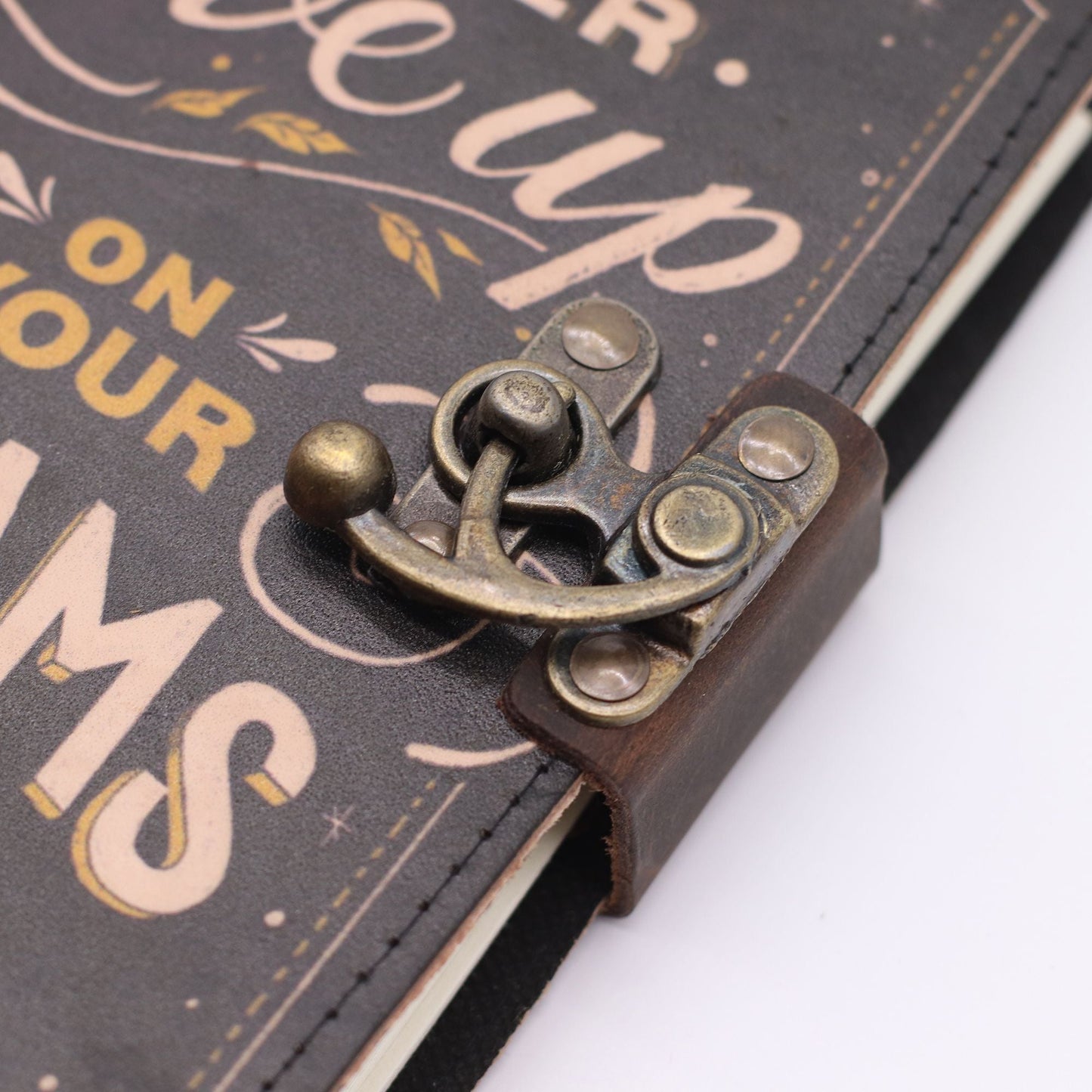 Printed Leather Notebook – 17.8 × 12.7 CM Never Give Up On Your Dreams, detalle de cierre metálico en cubierta de cuero impresa