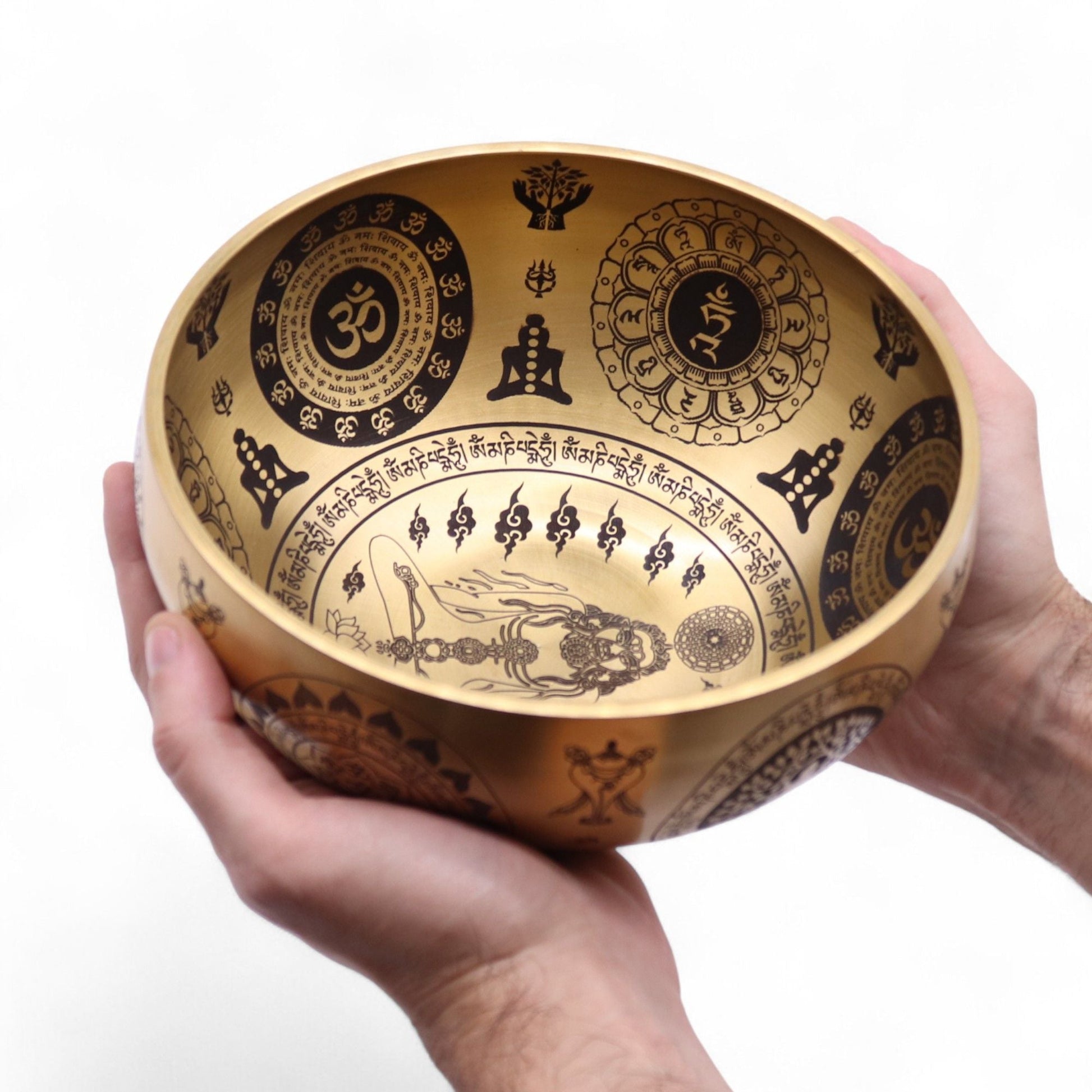 Alt Tag: Tibetanska klangskålar i ren mässing – set om 4 – 3.85KG, cuenco tibetano de latón med graverade spirituella symboler, hålls i händerna