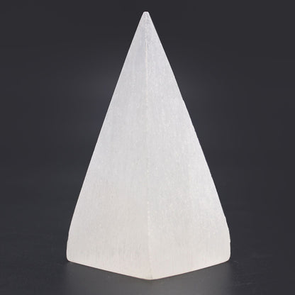 Radiant Selenite Pyramid – 10 CM crystal pyramid, white polished selenite stone decor piece on dark background
