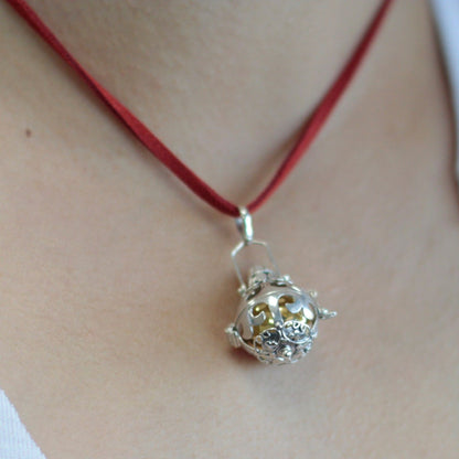 Alt Tag: Radiant Silver Angel Bell – Magic 18MM 925 silver bell pendant necklace on red cord, close-up on neck