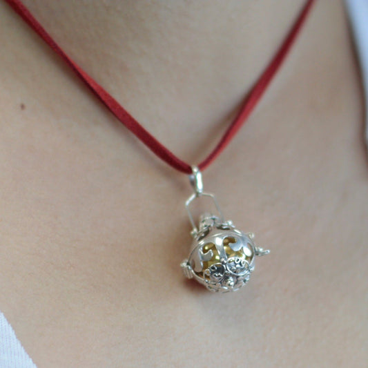 Alt Tag: Strålande silverfärgad änglaklocka – Magic 18MM halsband med klockhängsmycke i 925 silver på röd snodd, närbild på halsen