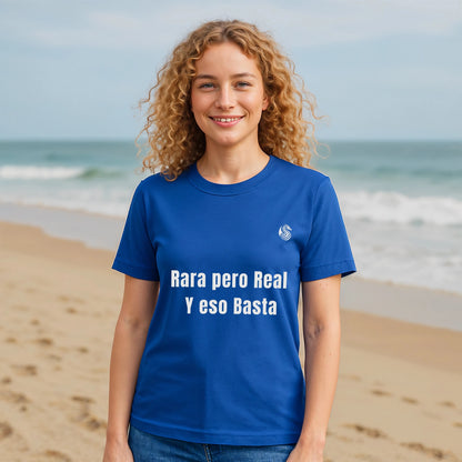 Rara Pero Real Eso Basta Drix Sustainable Unisex Tee en azul, modelo en la playa con texto “Rara pero Real y eso Basta”