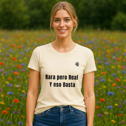 Alt Tag: Mujer usando Rara Pero Real Eso Basta Drix Sustainable Unisex Tee color crema con texto “Rara pero Real y eso Basta” en campo de flores
