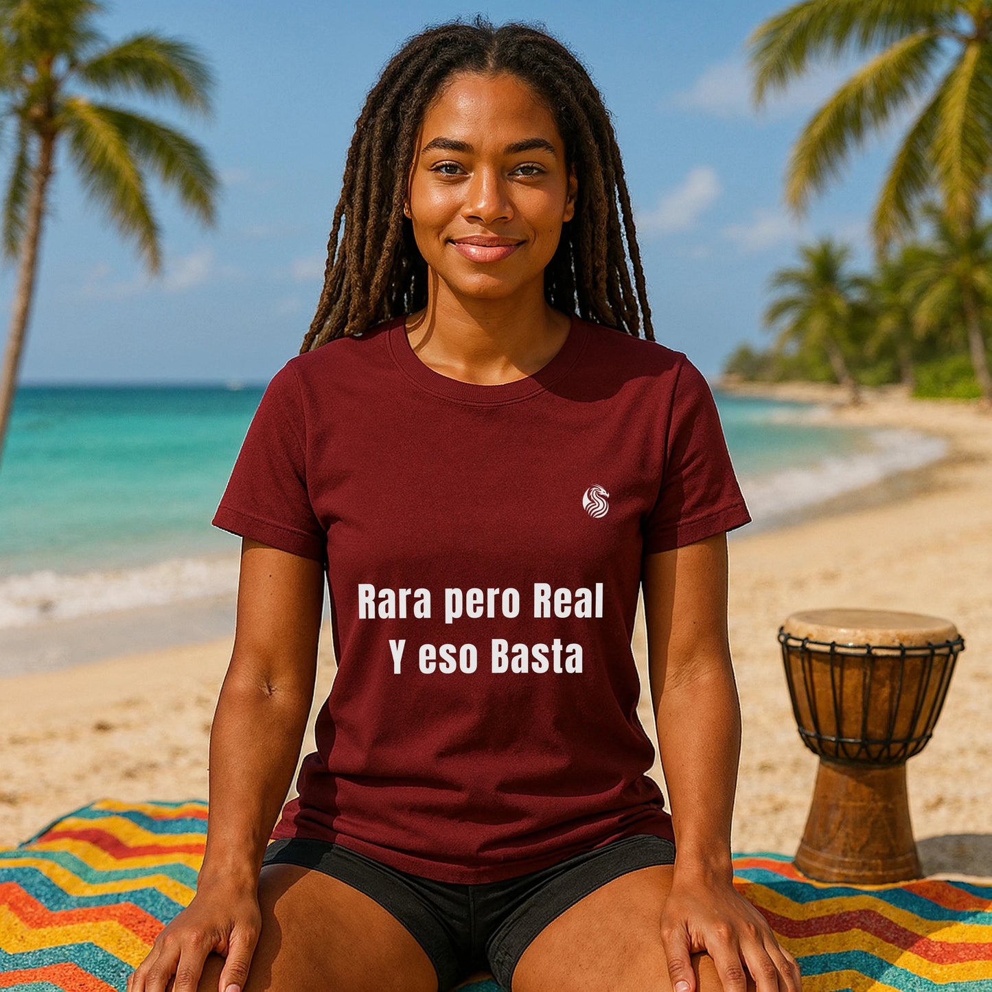 Rara Pero Real Eso Basta Drix Sustainable Unisex Tee camiseta granate con texto "Rara pero Real y eso Basta" en modelo sentada en playa