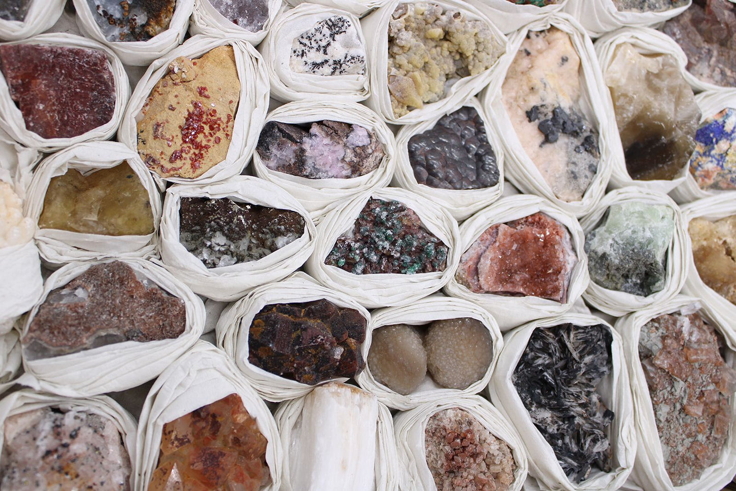 Alt Tag: Rare Mineral Specimens Set – 24 Assorted Pieces, close-up of 24 assorted mineral rocks wrapped in white tissue