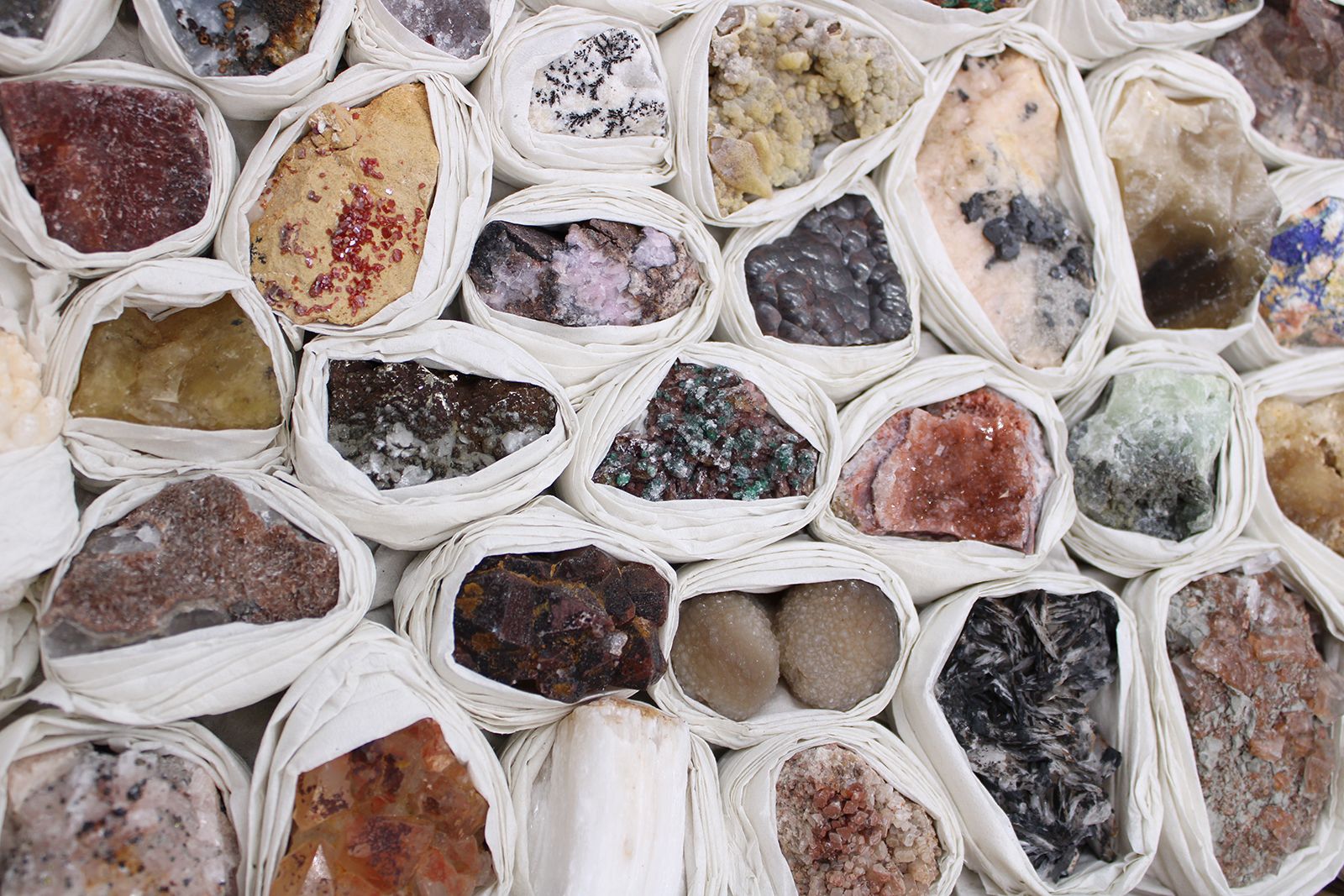Alt Tag: Rare Mineral Specimens Set – 24 Assorted Pieces, close-up of 24 assorted mineral rocks wrapped in white tissue