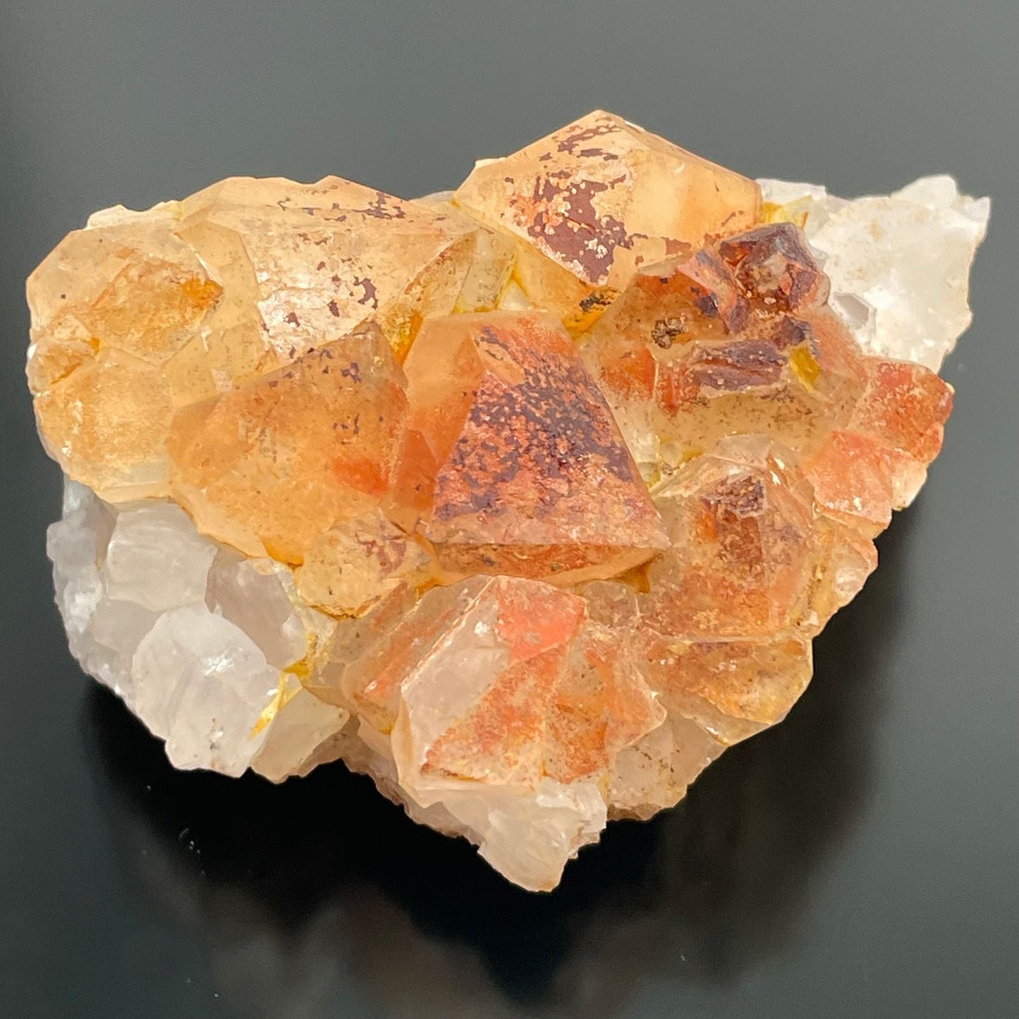 Alt Tag: Rare Mineral Specimens Set – 24 Assorted Pieces orange crystal cluster mineral specimen with translucent formations on dark background