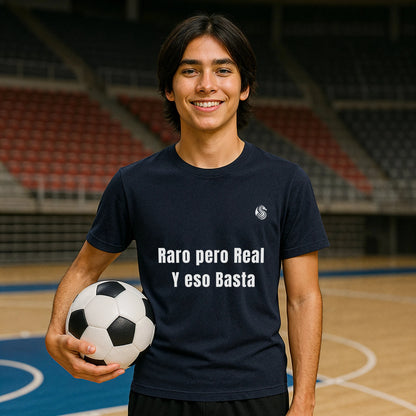 Alt Tag: Raro Pero Real Eso Basta % Drix 100% Organic Cotton T-Shirt en azul marino, modelo sosteniendo balón de fútbol en cancha interior