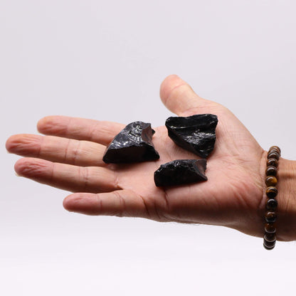 Alt Tag: Raw Crystals (500gm) - Black Obsidian raw black obsidian stones shown in hand, natural unpolished crystal pieces