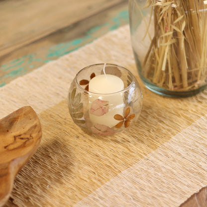 Alt Tag: Portavelas de vidrio reciclado – Primavera 8x10 CM con vela tipo tealight, flores prensadas en vidrio reciclado sobre mesa rústica