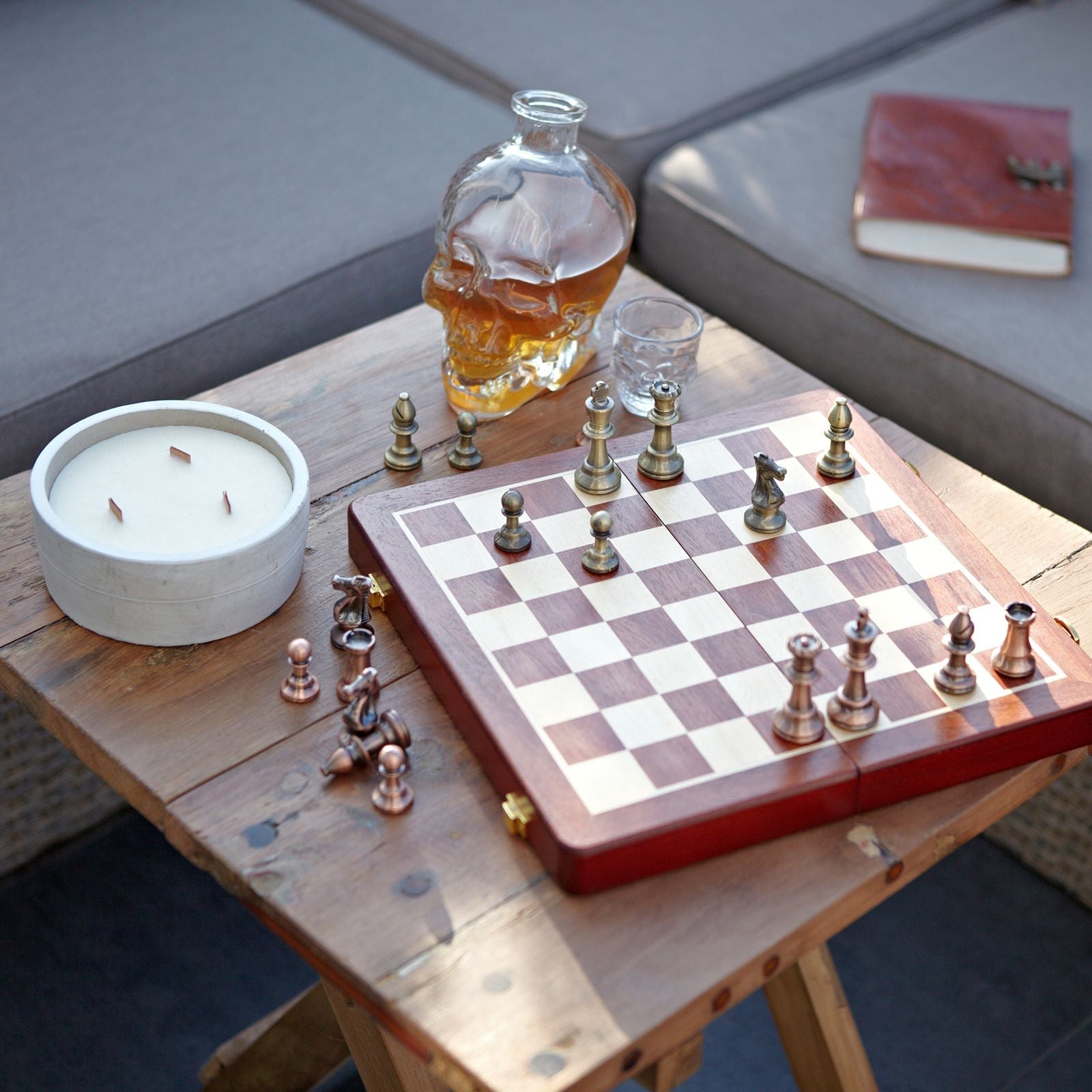 Alt Tag: Recycled Teak Folding Coffee Table – 50x50CM with chessboard, pieces, candle and glass decanter on rustic teak surface