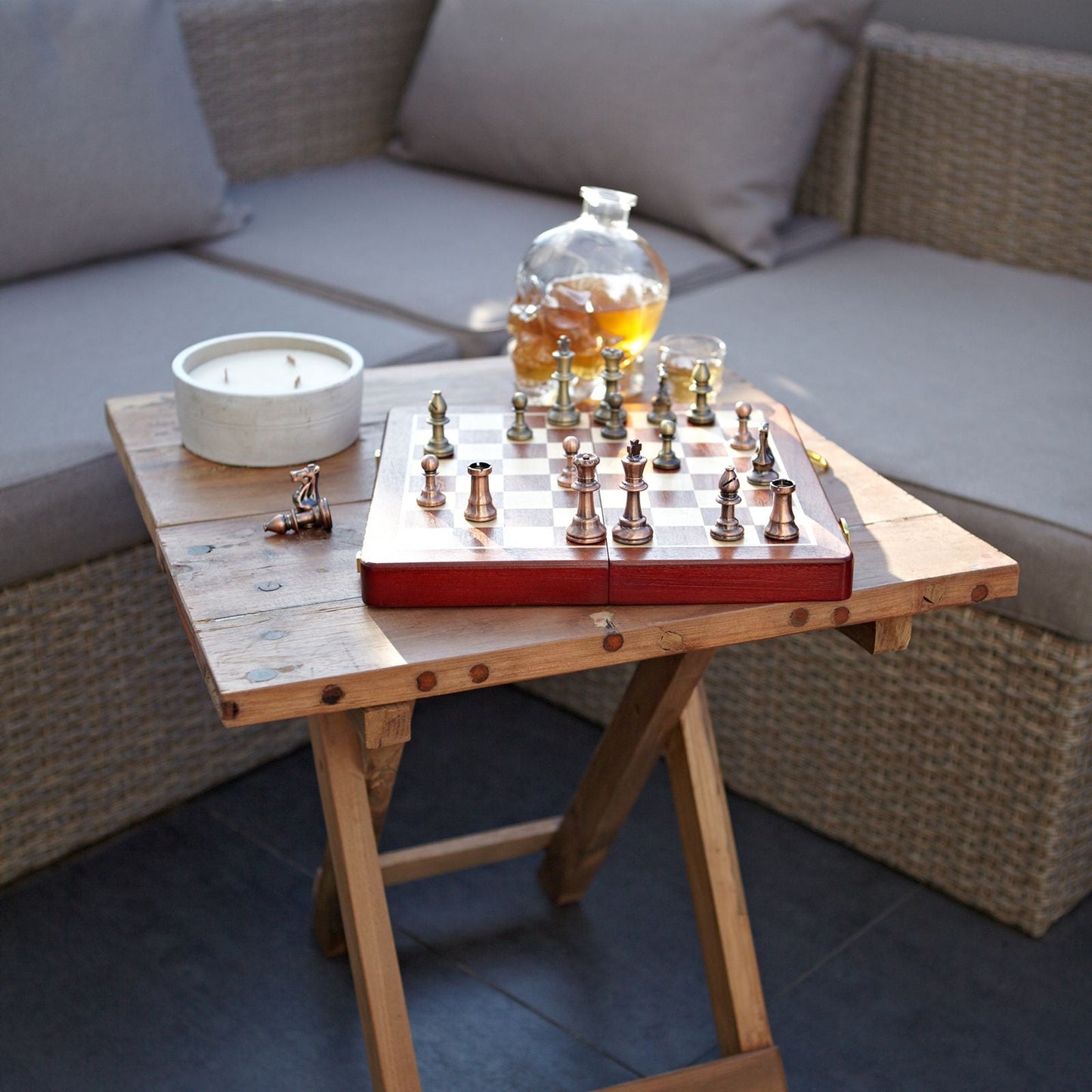 Recycled Teak Folding Coffee Table – 50x50CM with chess set and candle on rustic reclaimed teak folding patio table