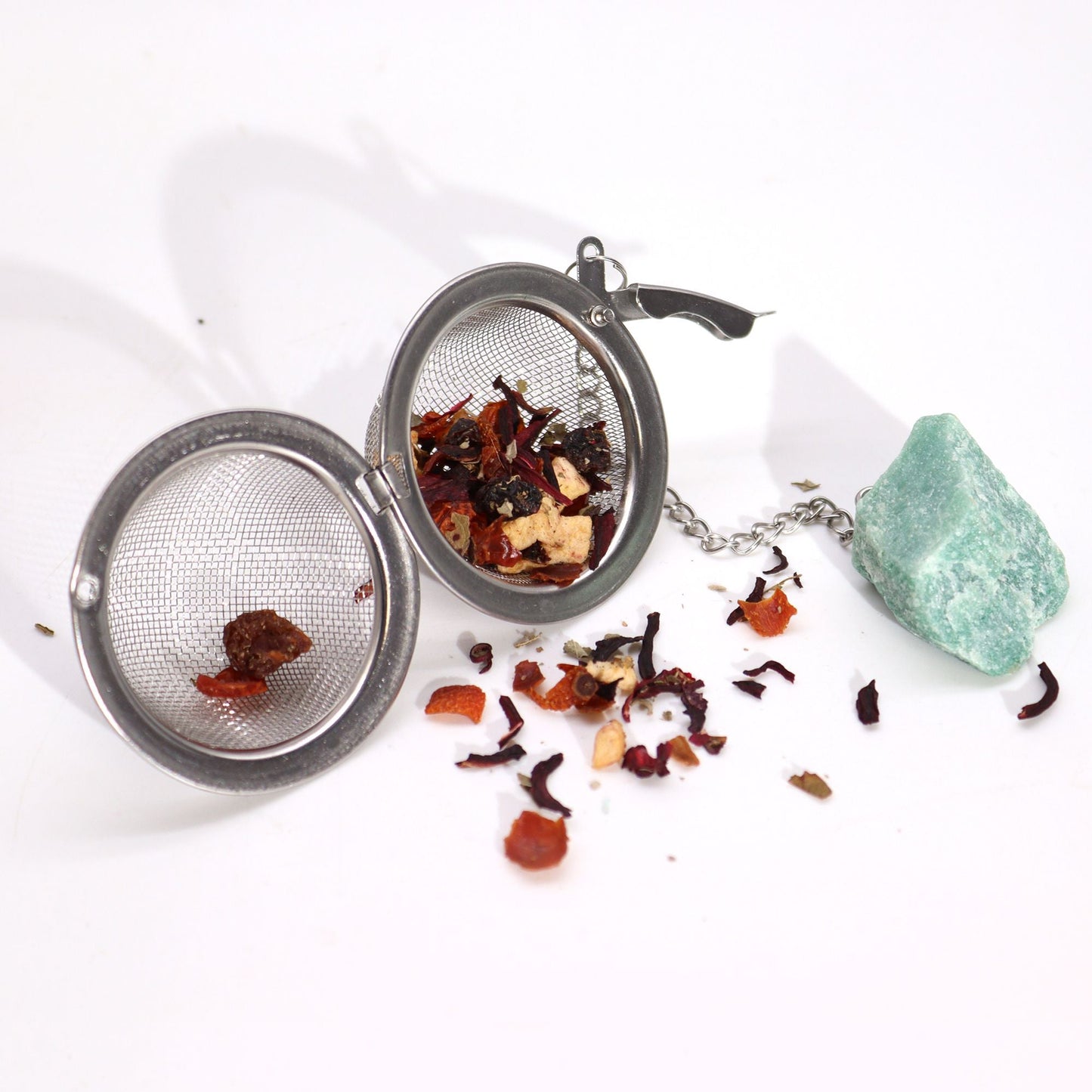 Alt Tag: Red Jasper Crystal Tea Strainer – 7.5x5 CM stainless steel mesh tea infuser with loose leaf tea and gemstone on white background
