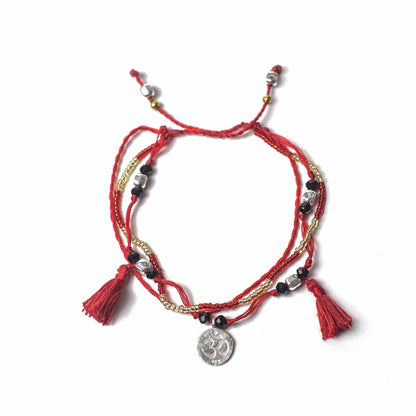 Alt Tag: Red Temple String Bracelet – Endless Knot bracelet in red string with beads, metal chain, tassels and Om charm, adjustable unisex