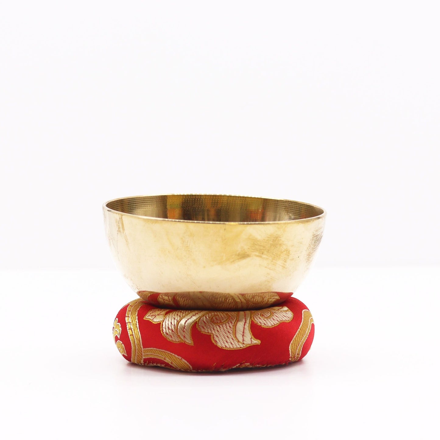 Red Textile Singing Bowl Cushion – 8CM with gold floral pattern supporting a brass singing bowl on white background