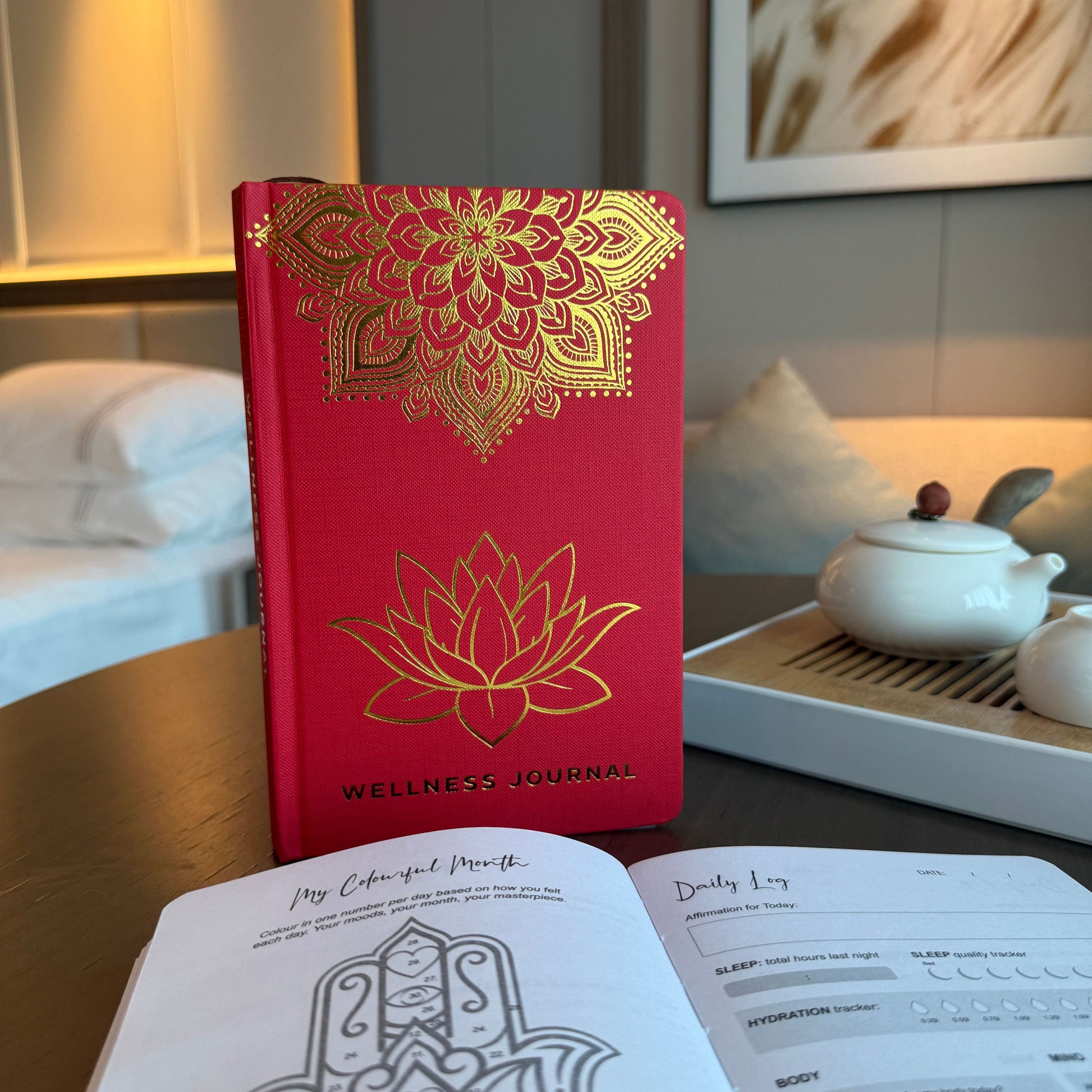 Red Wellness Journal – 120 Pages – Golden Mandala & Lotus, red cover notebook with gold mandala and lotus design on a desk