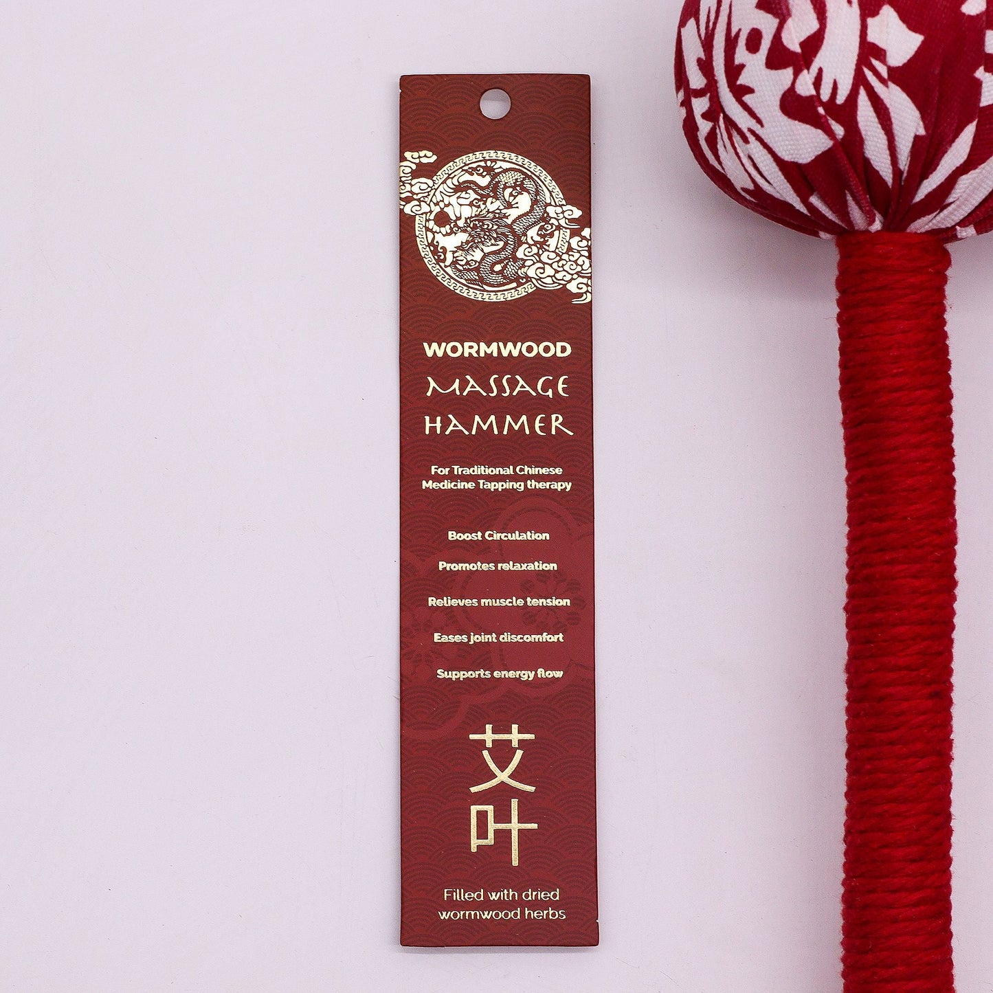 Alt Tag: Red Wormwood Massage Hammer – Wooden Tool with red-and-white fabric head and red handle, shown with product hang tag