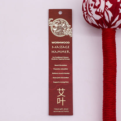 Alt Tag: Red Wormwood Massage Hammer – Wooden Tool with red-and-white fabric head and red handle, shown with product hang tag