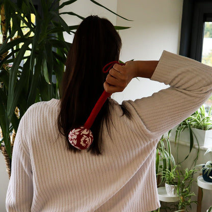 Red Wormwood Massage Hammer – Wooden Tool used for rhythmic tapping massage on upper back, red handle and patterned head