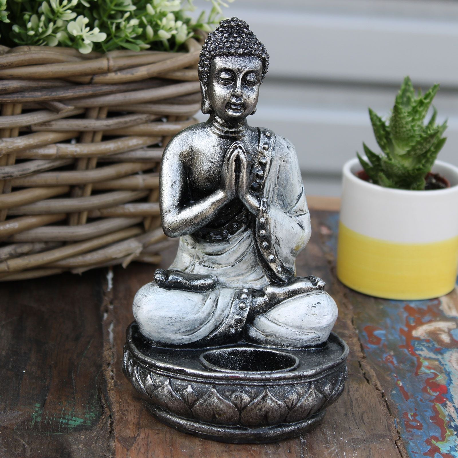 Alt Tag: Buddha-ljushållare i resin – Vit Medium, medelstor Buddha i resin med händerna i bön och ljuskopp på rustik bordsdekoration