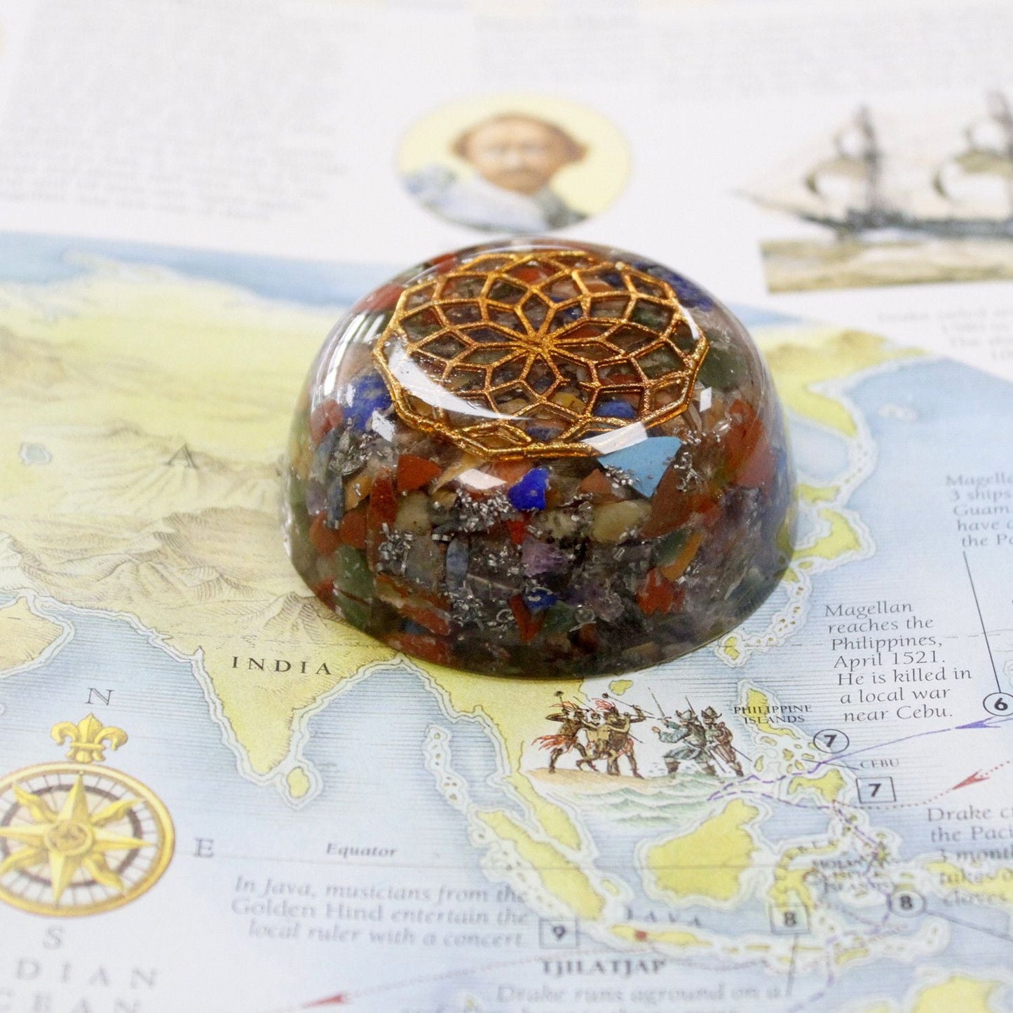 Resin Gemstone Orgonite Dome – Multi Stone 6.5CM resin dome with multi stone chips and gold geometric emblem on map background
