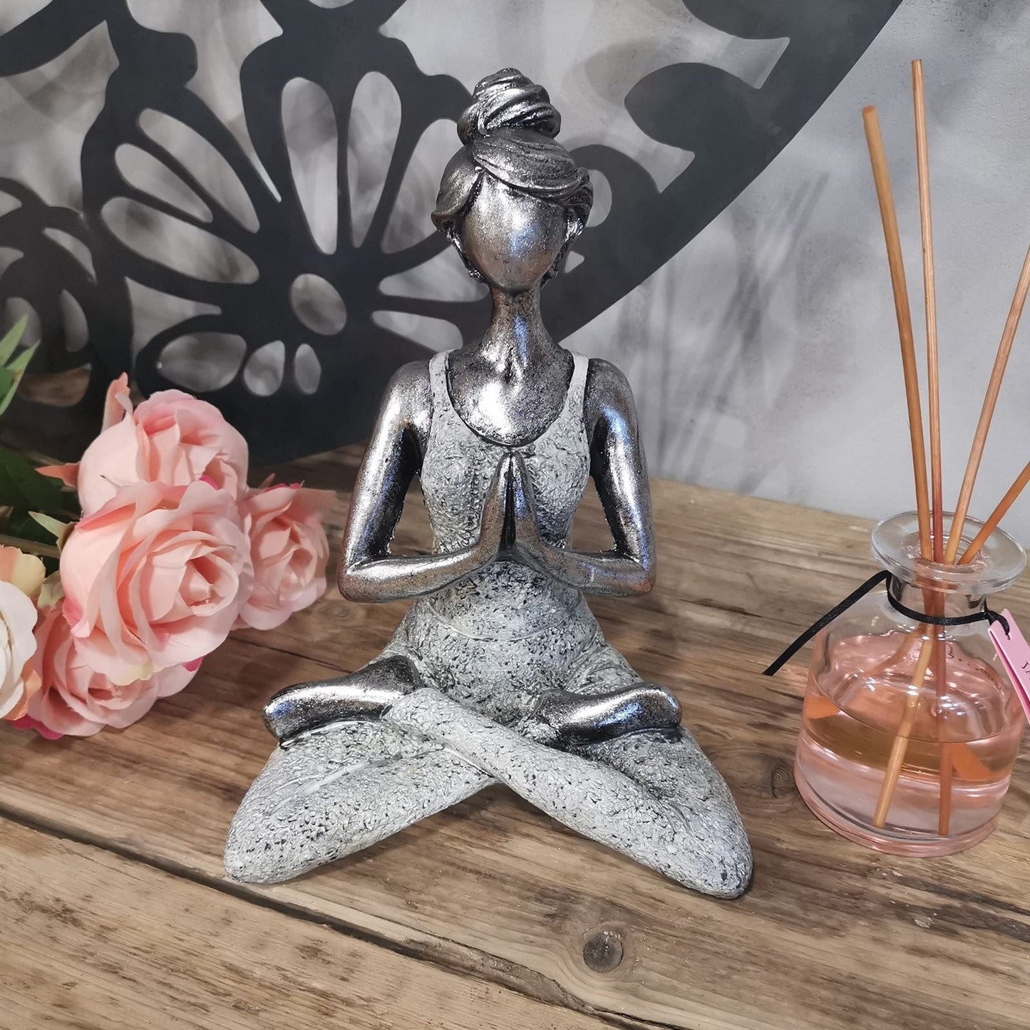 Alt-Tag: Resin Yoga Lady Figur – Silber & Weiß 24CM, sitzend in Gebets-Yoga-Pose, silber-weiße Resin-Statue als Deko auf einem Holztisch