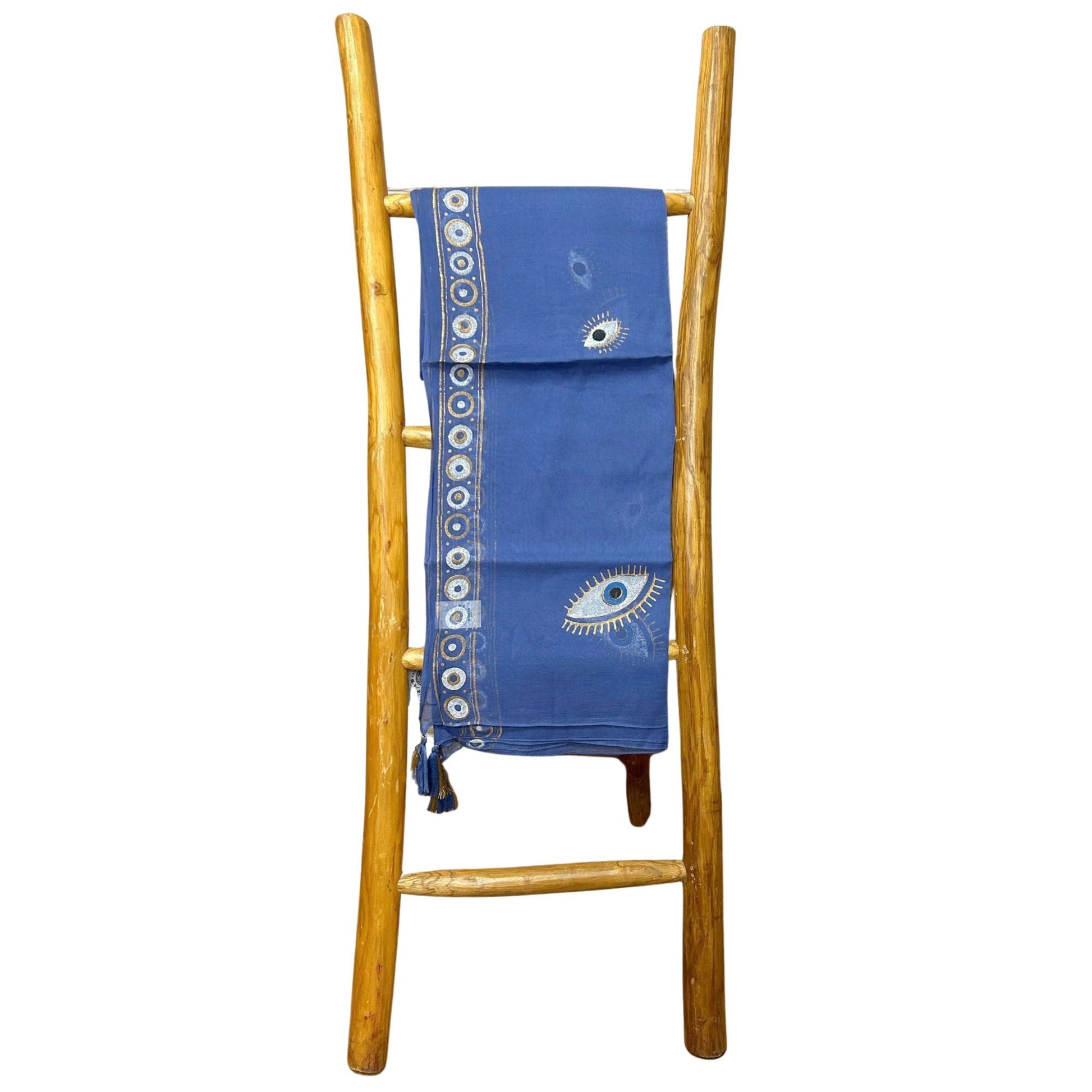 Rich Blue & Gold Pure Cotton Sari – 180x110 CM draped on wooden ladder, deep blue cotton sari with gold border and eye motif