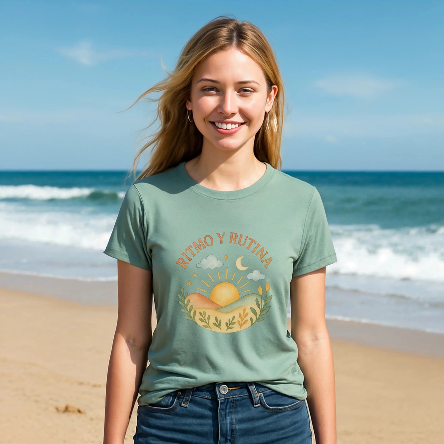 Alt Tag: Ritmo Rutina Organica Premium Unisex T-Shirt verde salvia con gráfico “RITMO Y RUTINA” sol y luna, modelo en la playa