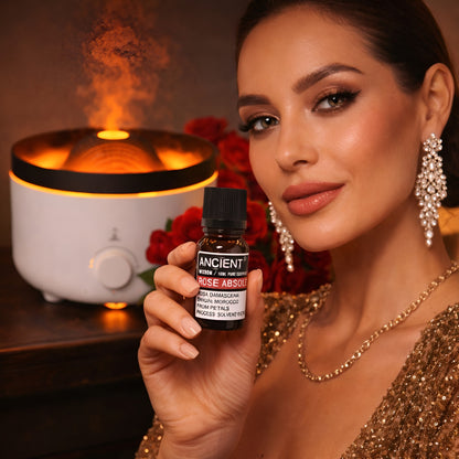Alt-tag: Rosa Centifolia Essential Oil – 10 ML flaska med eterisk rosolja med aromadiffuser och röda blommor i bakgrunden