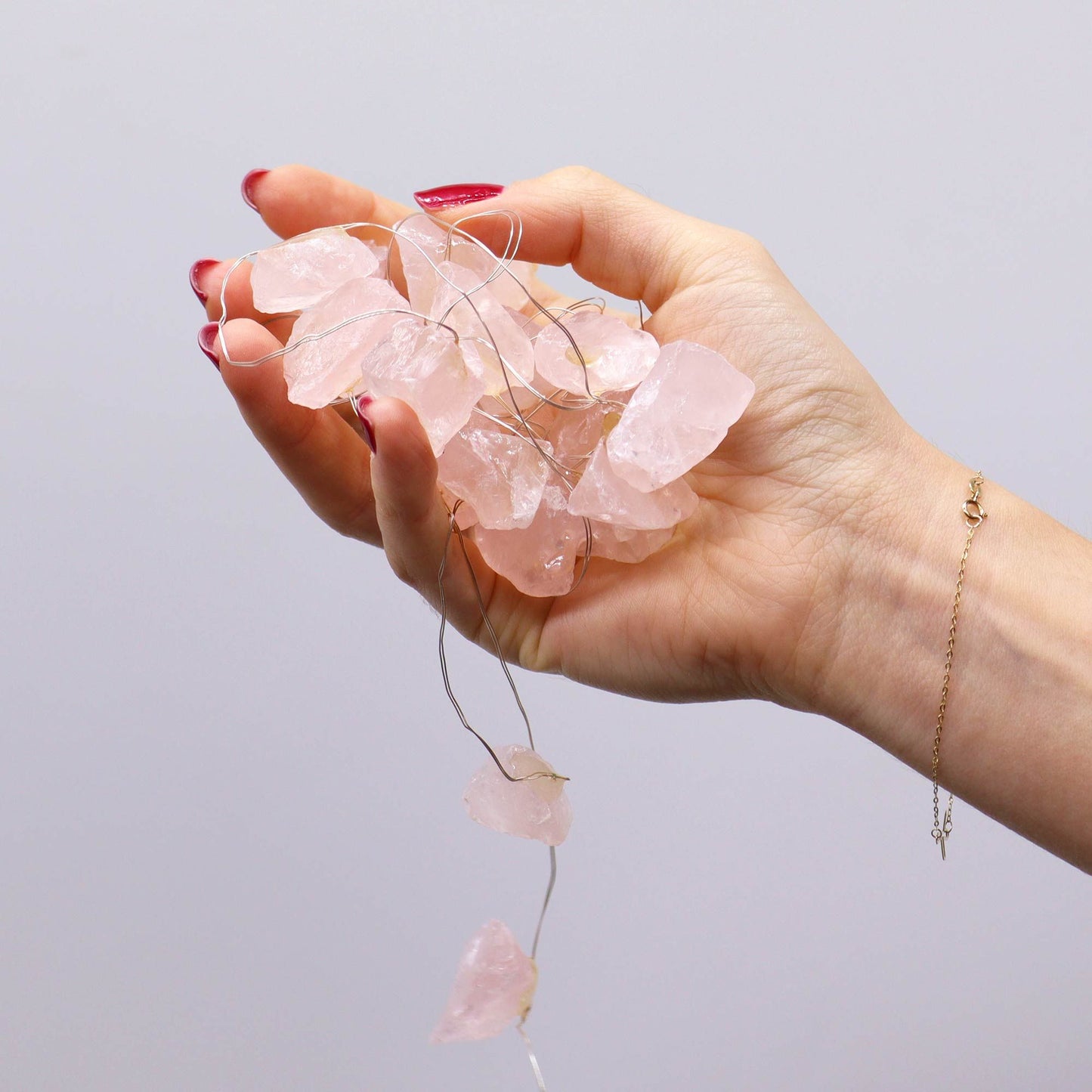 Alt Tag: Rose Quartz Gemstone Enchantment Lights – Decorative String held in hand with pink rose quartz stones on wire string lights